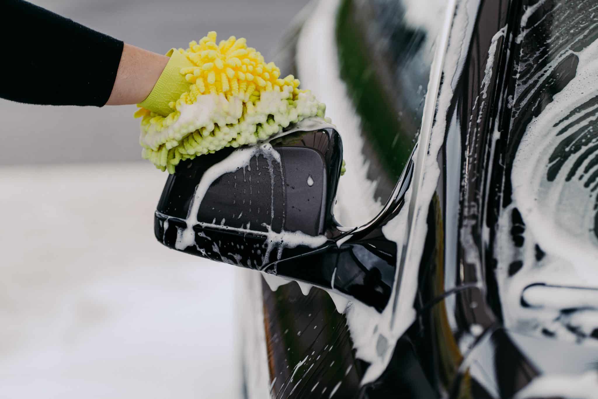 mans hand holding sponge for washing car black au 2026 01 08 22 24 58 utc